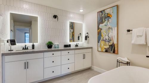 a bathroom with two sinks and a large mirror at Ski La Vie by AvantStay Hot Tub Game Room Near the Ski Slopes in Heber City