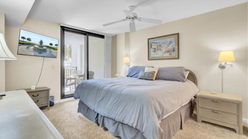 a bedroom with a bed and a large window at 123D Shipwatch by AvantStay Beach Access Pool in Isle of Palms