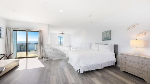 a white bedroom with a bed and a balcony at Oceanfront 2BR Rooftop Deck Beach Access Strand Way B in Oceano