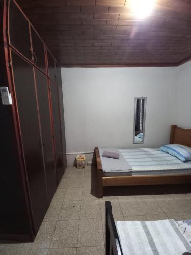 una habitación con dos camas y un armario y una cama en Hospedaje carvajal, en David