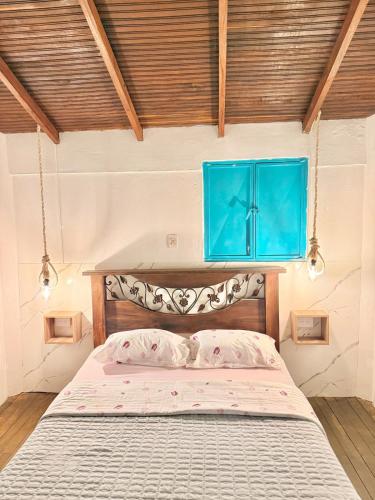 a bedroom with a bed with a blue cabinet above it at Cabaña frente al Río-Curití-San Gil in Curití