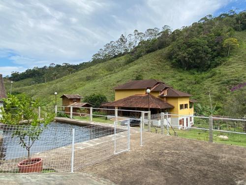 Sítio Reichart Atlantic Forest Retreat في ماريشال فلوريانو: مبنى فيه سياج امام تل