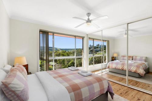 een slaapkamer met twee bedden en een groot raam bij Ziggy's Place in Gerringong