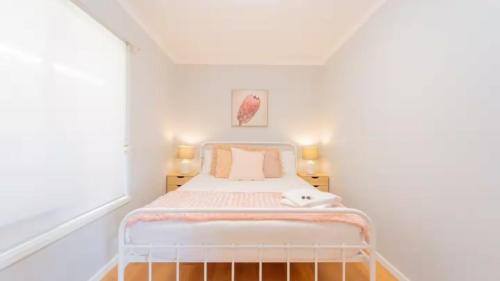 EpsomNouveau Home的一间小卧室,在白色的房间里配有一张床