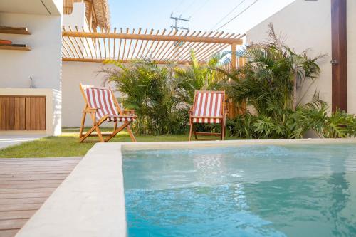 two chairs and a swimming pool in a yard at Villa Vento in Camocim