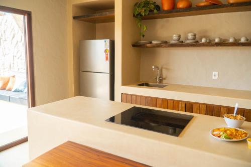 カモシンにあるCasa Alvorada - Villa Ventoの冷蔵庫とカウンターの上に食べ物の入ったボウルがあるキッチン