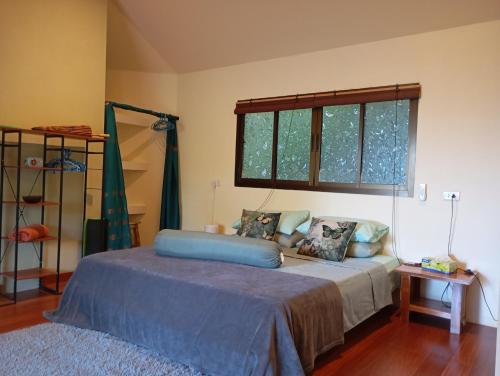 een slaapkamer met een bed met blauwe lakens en een raam bij Butterfly Cottage Tracy Island Had Yao in Ko Pha Ngan