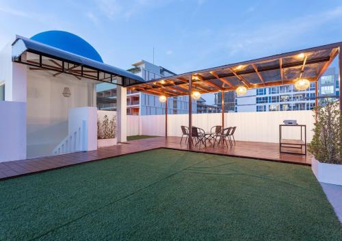 a rooftop patio with a green lawn on a building at Downtown Oasis 芭提雅市中心独栋泳池别墅 B 5卧6卫 KTV BBQ 芭提雅海滩步行街500m in Pattaya