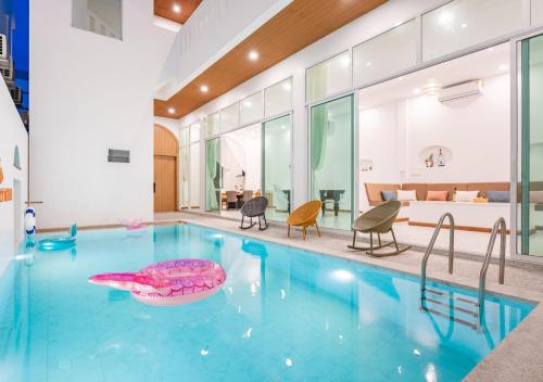 a large swimming pool with a pink object in the middle at Downtown Oasis 芭提雅市中心独栋泳池别墅 B 5卧6卫 KTV BBQ 芭提雅海滩步行街500m in Pattaya