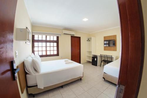 una habitación de hotel con dos camas y una mesa en Vale Confort Hotel, en Petrolina