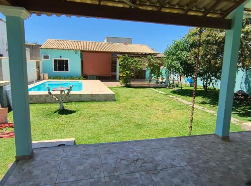 a yard with a swimming pool and a house at Casa da Lagoa Azul in Arraial do Cabo