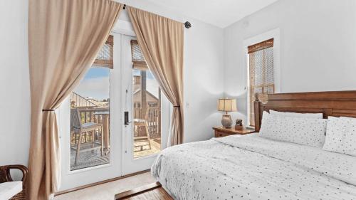 Red Fish Blue Mountain by AvantStay Private Beach Gulf View في شاطئ سانتا روزا: غرفة نوم بها سرير ونافذة كبيرة