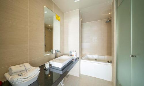 a bathroom with a sink and a toilet and a tub at Wolmido Premiers Hotel in Incheon