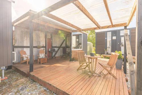 RuatapuにあるRimu View 3 by Tiny Awayのパティオ(椅子とテーブル付きの木製デッキ付)