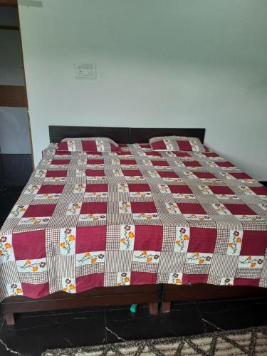 a bed with a red and white quilt on it at DS Villa in Noida