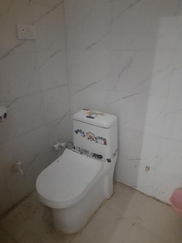 une salle de bain avec des toilettes blanches dans une chambre dans l'établissement DS Villa, à Noida