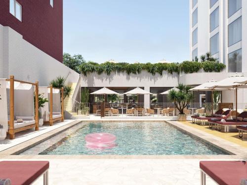 una piscina con mesas y sombrillas en un edificio en Hyde Perth, en Perth