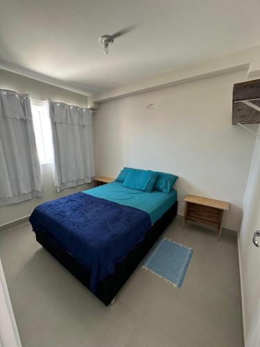 a bedroom with a blue bed and a window at Bela Vista in Matinhos