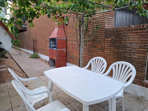 a white table and chairs and a brick oven at Linda Cabana 3 Quartos a 50m da Praia in São Lourenço do Sul