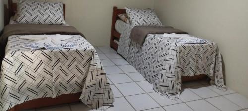 Dos camas una al lado de la otra en una habitación. en FLAT MONTE CASTELO CONDOMÍNIO GRAVATÁ NA FRENTE DA ÁREA DE LAZER - Pe, en Sairé