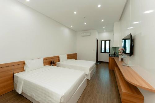 Un dormitorio con dos camas y un televisor. en TD Apartment, en Hai Phong