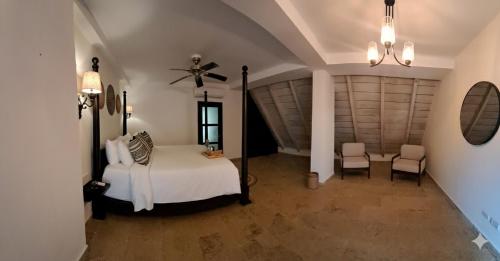 a bedroom with a bed and two chairs at Hotel Boutique Patio Corao in Cartagena de Indias