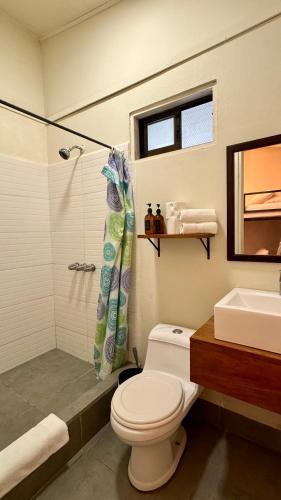 a bathroom with a toilet and a shower and a sink at Alalunga Casas in Puerto Viejo