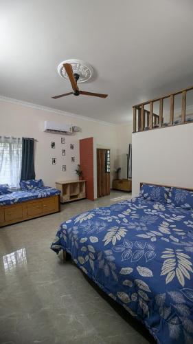 a bedroom with two beds and a blue comforter at REJOICE Homestay - 1BHK private stay in Kalyānpur