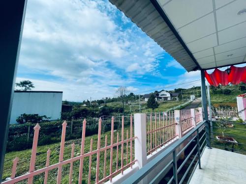Cloudy homestay في Bảo Lâm: منظر من شرفة منزل ذي سياج وردي