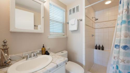 a bathroom with a sink and a toilet and a window at Steps to Beach w PatioDeck Foosball Happy Bottom Beach House by AvantStay in Oceano