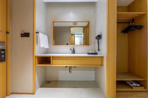a bathroom with a sink and a mirror at JI Hotel Shanghai Changshou Road in Shanghai