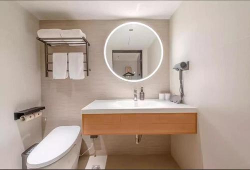 a bathroom with a sink and a toilet and a mirror at JI Hotel Guangzhou Ximenkou in Guangzhou