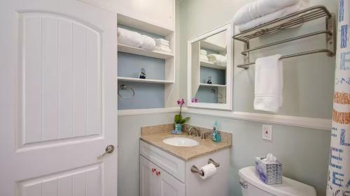 Waterfront Views Shared Dock Short Walk to Beach Shops Surf Edgewater B by AvantStay في شاطئ نيوبورت: حمام مع حوض ومرحاض