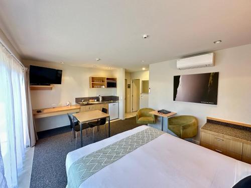 a hotel room with a bed and a kitchen at Park View Motor Lodge in Hamilton