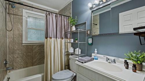 Un baño con lavabo, inodoro y ducha. en Frolic on Fern by AvantStay Enclosed Deck w Forest Views Bar, en Blakeslee