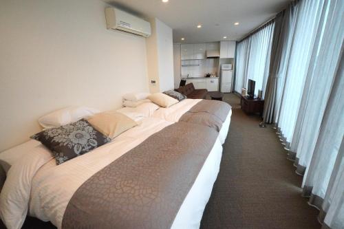 a row of beds in a hotel room at 3 Wellness in Okayama