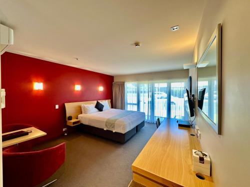 a bedroom with a bed and a red wall at Park View Motor Lodge in Hamilton