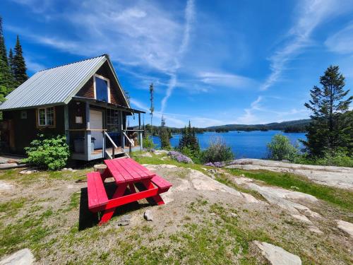 un tavolo da picnic rosso davanti a una piccola casa di Oyama Lake Lodge a Lake Country