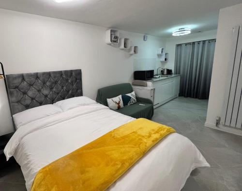 a bedroom with a large bed with a yellow blanket on it at Sheffield Modern Studio with Free EV Charging in Sheffield