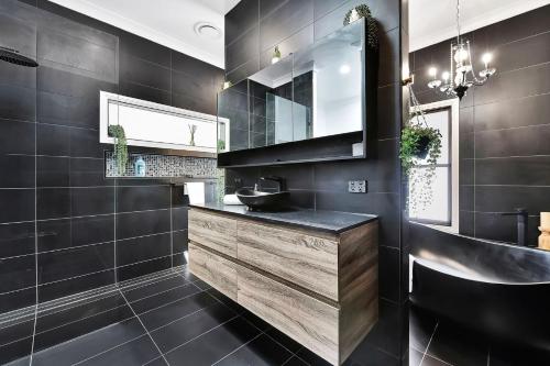 Black Cat Manor at B&W Estate في Luskintyre: حمام أسود مع حوض ومرآة