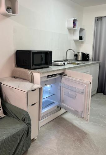 a kitchen with an open refrigerator and a microwave at Sheffield Modern Studio with Free EV Charging in Sheffield