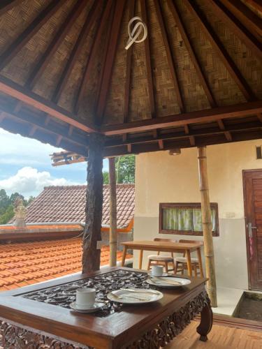 eine Terrasse mit einem Tisch und Tellern darauf in der Unterkunft Wayan Bola Homestay in Sidemen