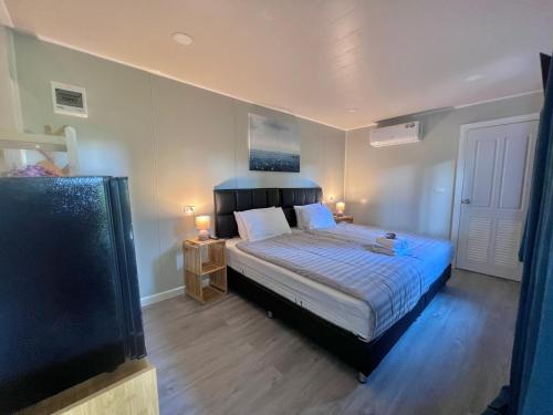 a bedroom with a bed and a tv in it at The Green Resort in Ko Chang