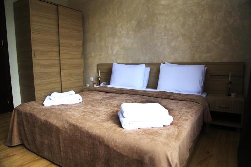 um quarto com duas toalhas brancas numa cama em Iveria Hotel em Khashuri