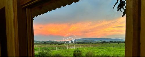 a view from a window of a field with a sunset at Finca hotel VillaLuna in Mesetas
