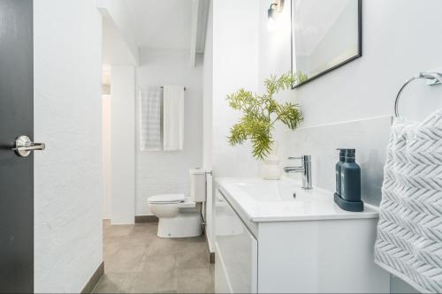 Quiet & Cozy 4 Bedroom Home في Norlane: حمام أبيض مع مرحاض ومغسلة