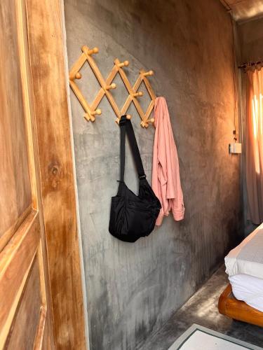 a room with a wall with a towel rack and a bag at Mơ House Eco Homestay on hill in Phú Quốc