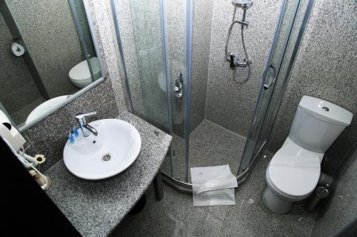 La salle de bains est pourvue d'une douche, d'un lavabo et de toilettes. dans l'établissement Iveria Hotel, à Khashuri