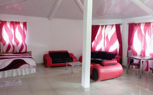 una habitación con dos sillas rojas y una cama en Ecotropicfarmhouse, en Cerro Azul