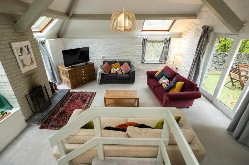 a living room with two couches and a tv at The Coach House in Llangollen